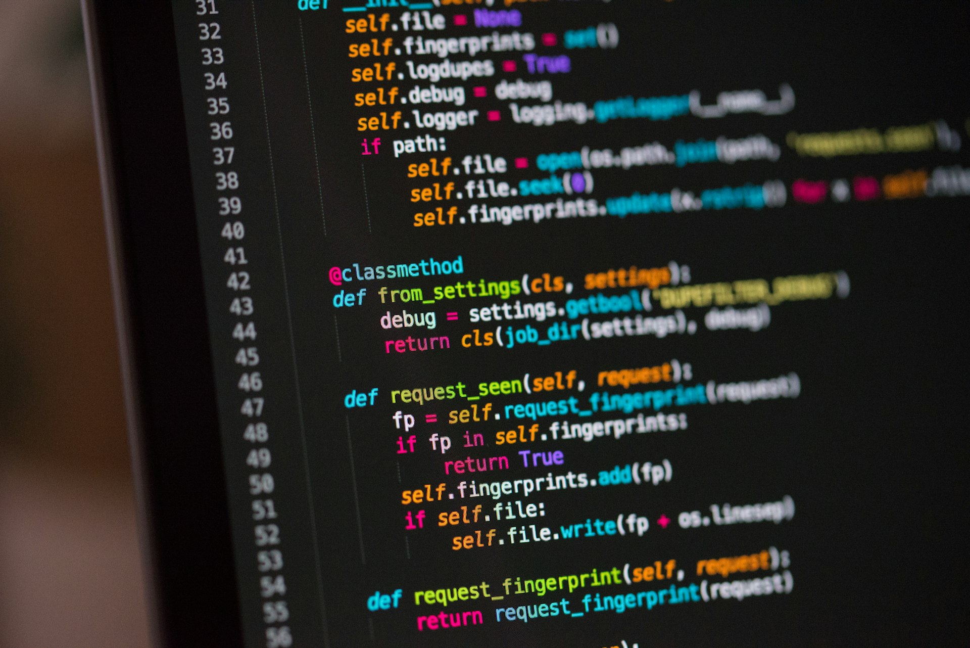 Dark desk with a monitor showing code